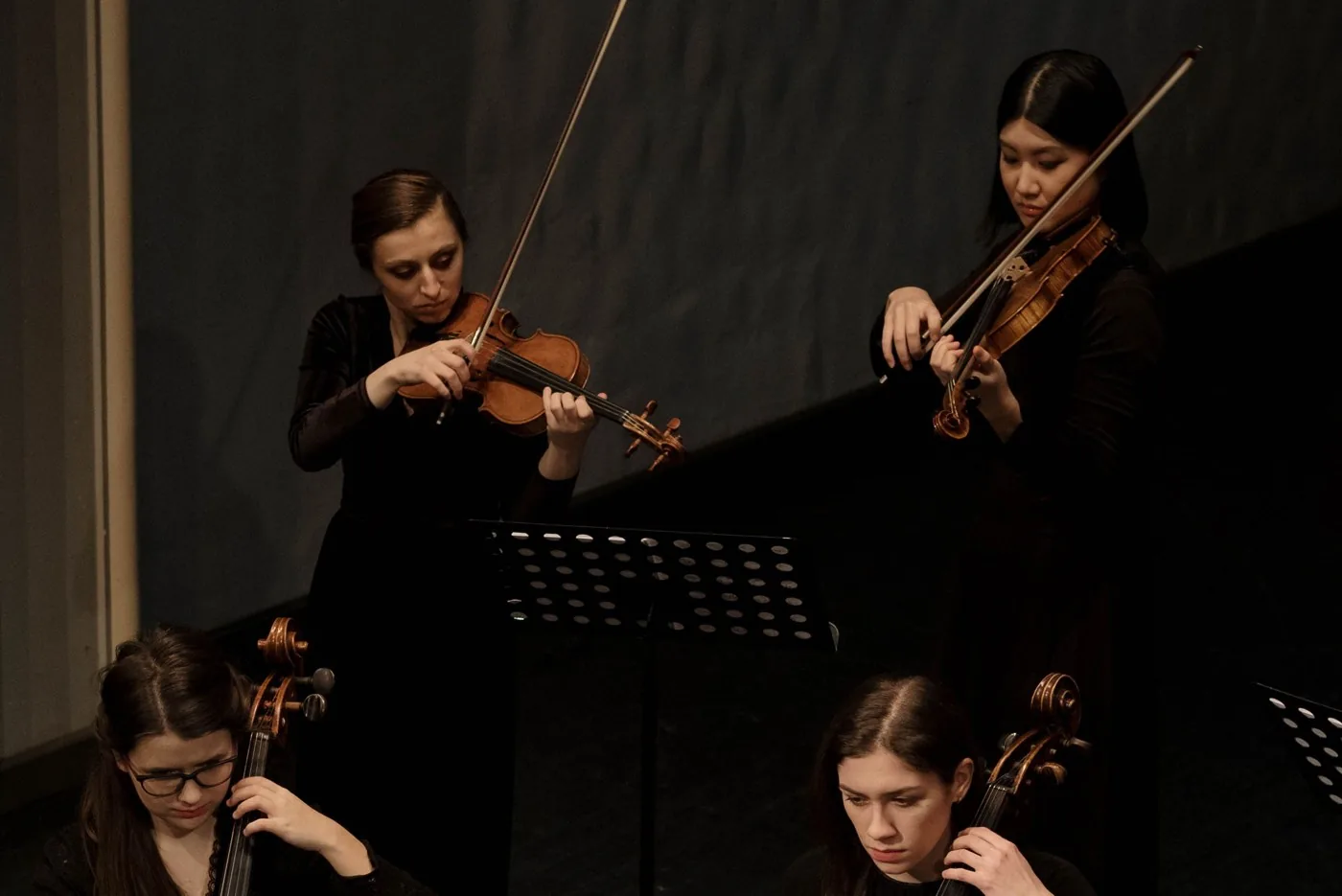 Músicas de cuerda interpretando una obra en concierto.